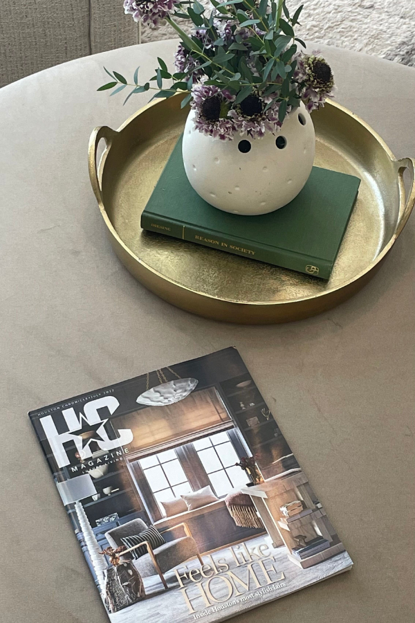 a vignette with magazine featuring LUDC interior design clients, flowers, a book and a tray