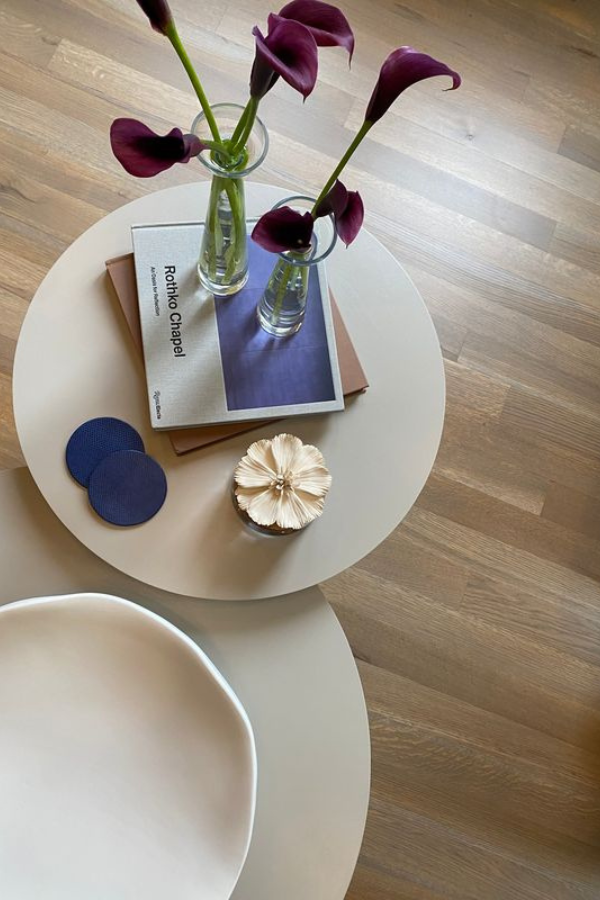 interior design books and flowers in vases on a coffee table