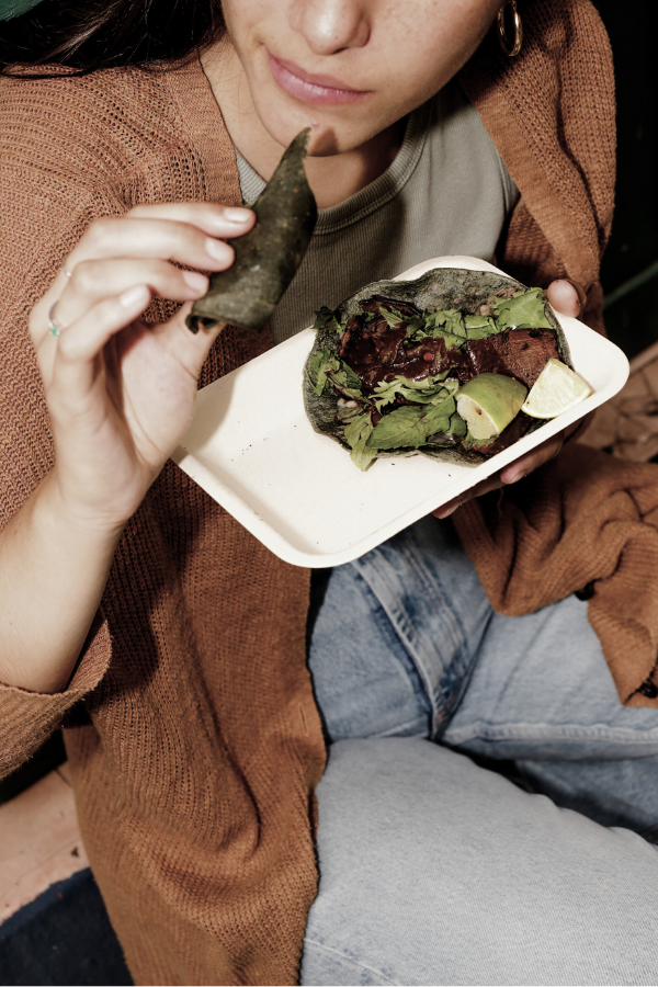 woman gets her plant-based meals delivered and eats tacos in jeans and cardigan