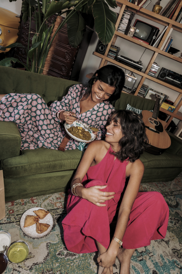 two women on a couch enjoy hobbies like cooking and playing guitar