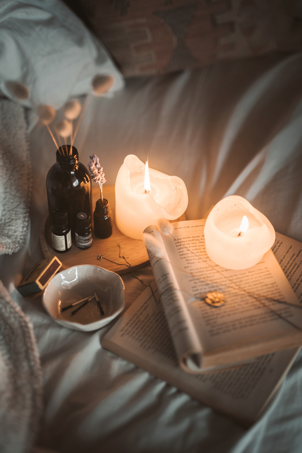 Candles on top of notebooks in a bed