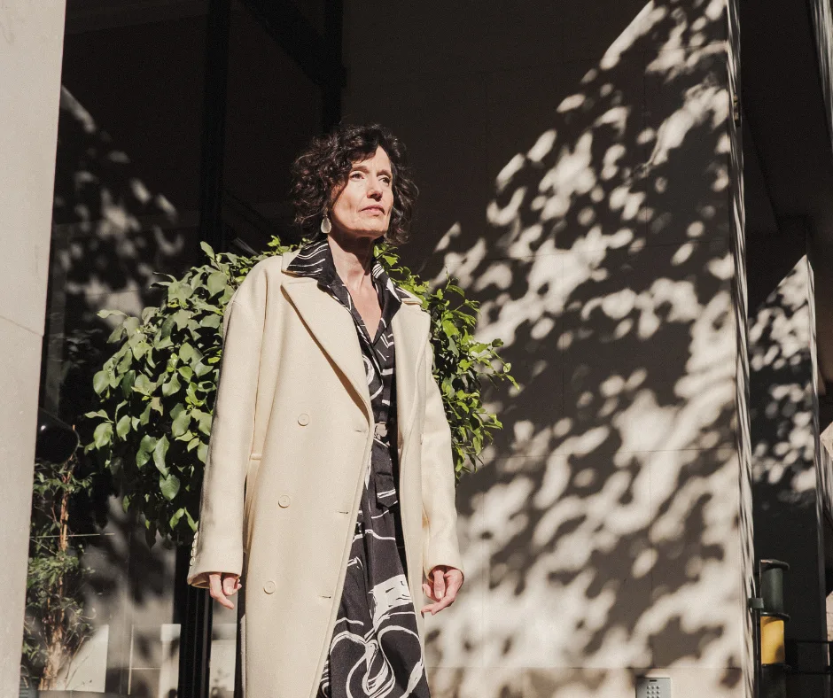 woman in a trench coat on her way to a workshop for upskilling