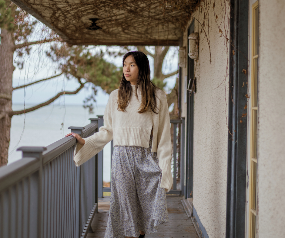 a woman outside on a wrap-around porch pondering time management strategies