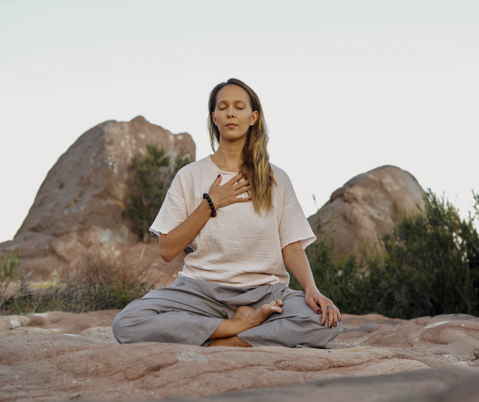 woman deep breathing on a rock practicing spiritual hygiene