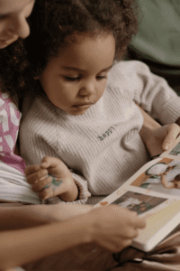a woman kinkeeping by showing her daughter a family album she created
