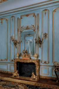 French rococo interior with a firebox and wood paneling painted blue