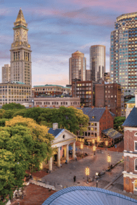 hotels in Boston set against the city's skyline at dusk with a square in the middle