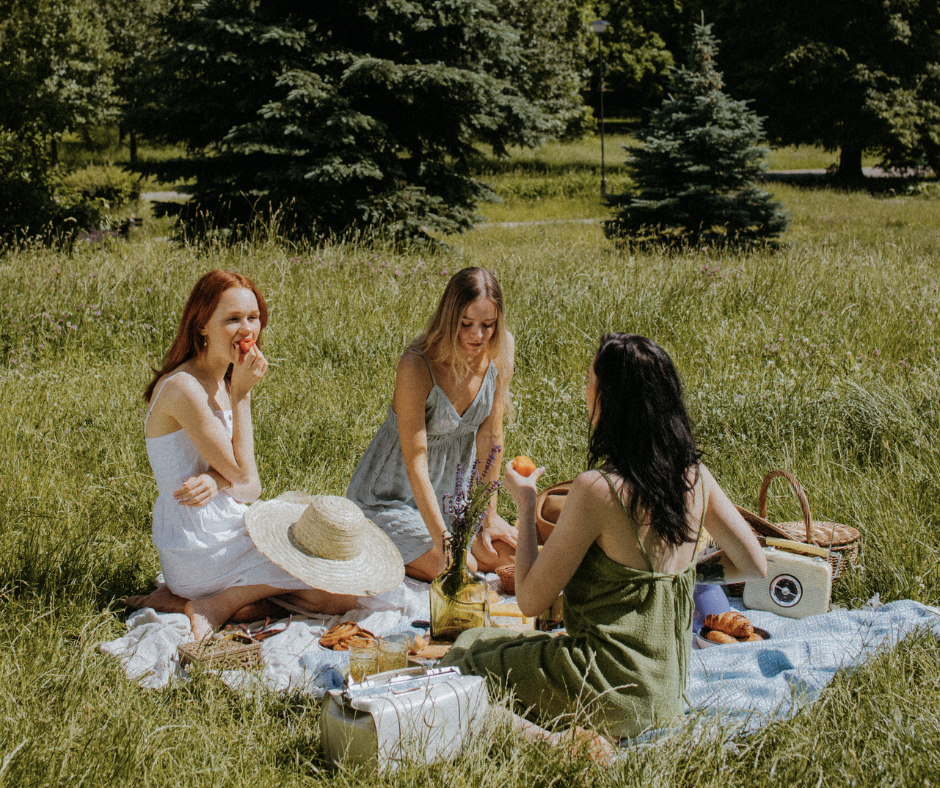 women gathering on a picnic blanket outdoors during summer