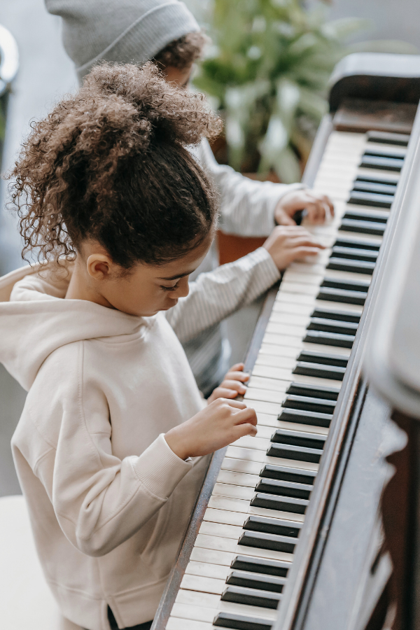 two children playing piano