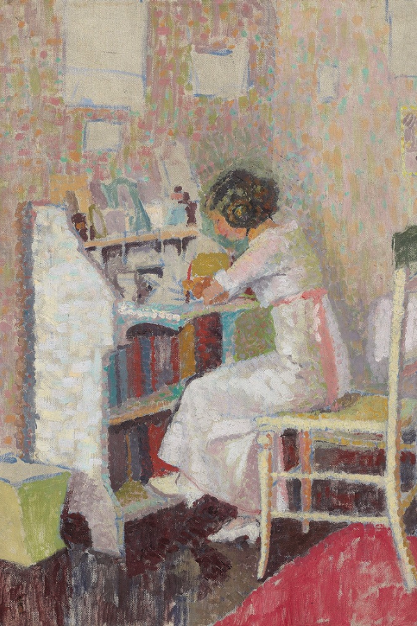 a woman writes at her desk