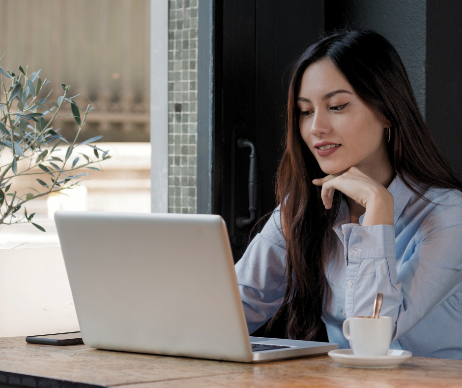 a woman sitting at her laptop in a cafe