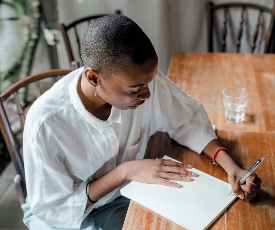 a woman writing at her dining table