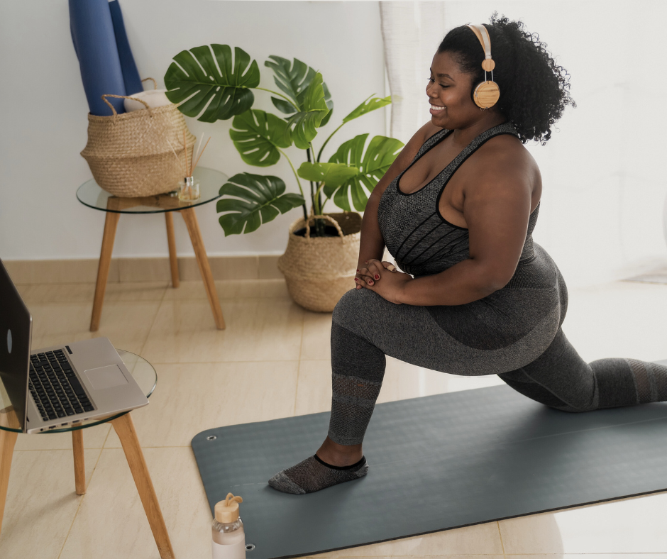 a woman does yoga and stretching in front of her laptop