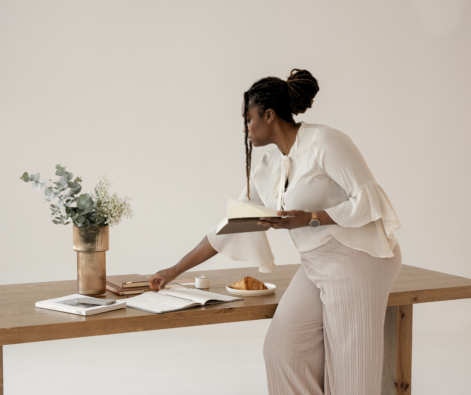 A woman adjusts papers on a desk