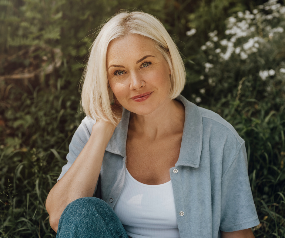 a woman wearing a blue and white top sits outdoors