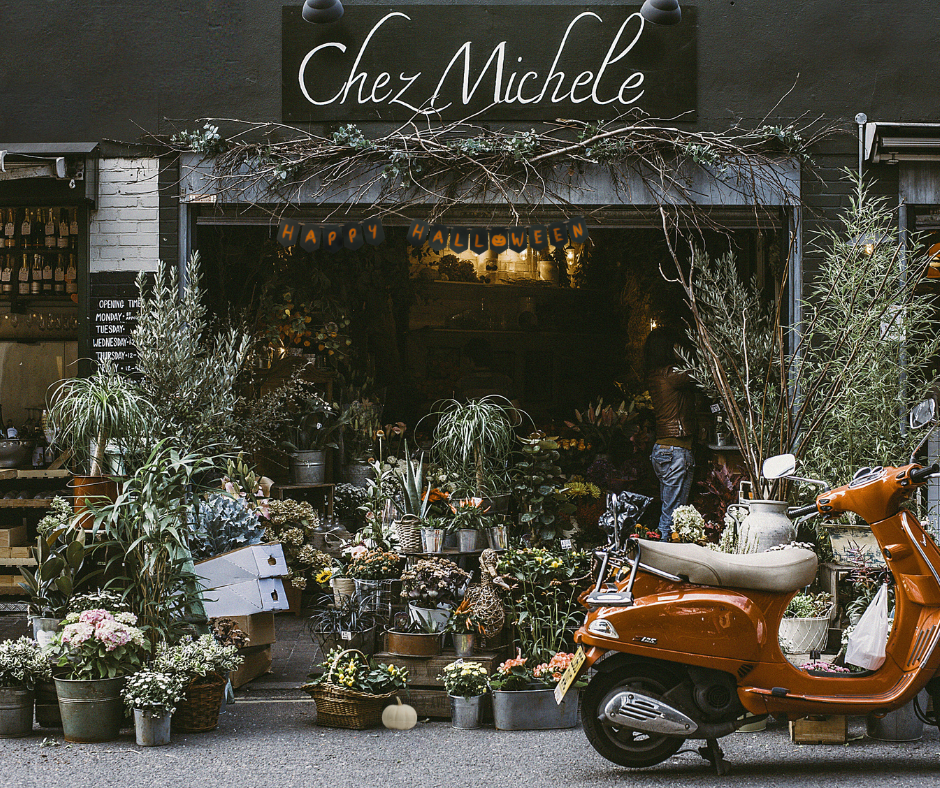 a plant store with a motorcycle and Halloween promotions outside