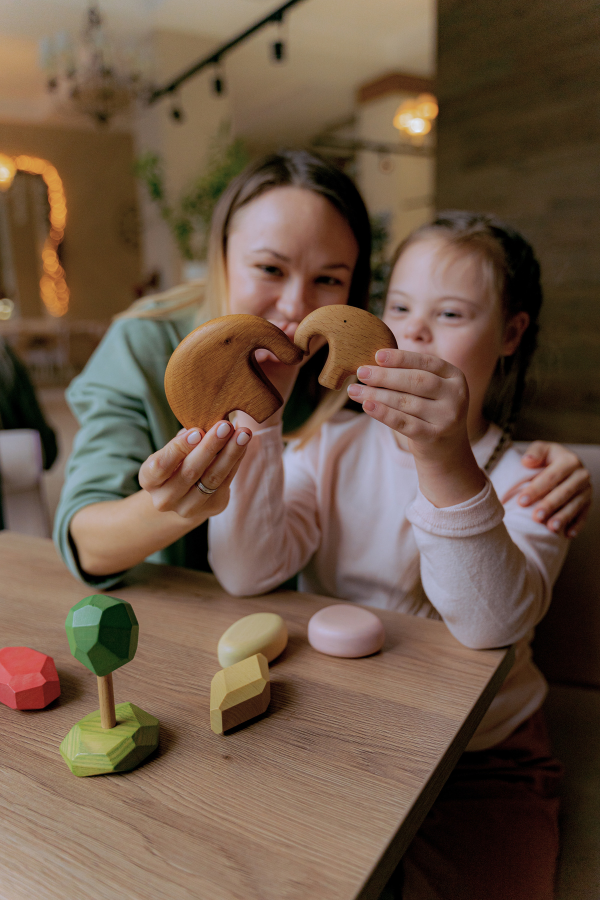 a mom and daughter playing with wooden toys