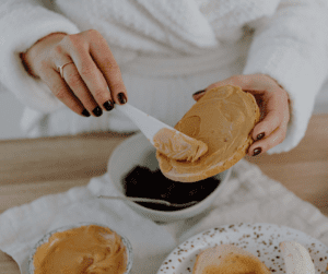 a woman making a peanut butter toast