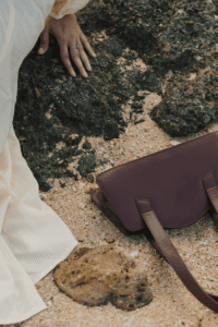 a woman with a purse sitting on a rock