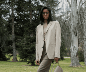 a woman wearing trousers, a turtleneck, and a blazer in the outdoors