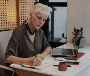 a woman gratitude journals at her desk