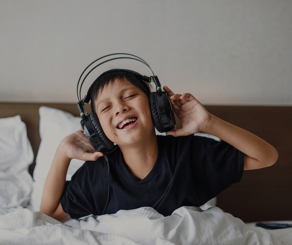 a young boy listens to a music for kids through headphones