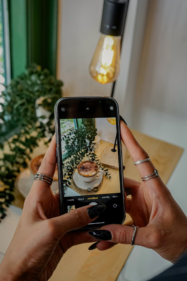 woman using Instagram on her phone in a cafe