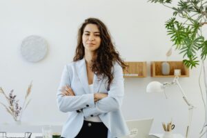 Confident businesswoman standing with arms crossed in a modern office