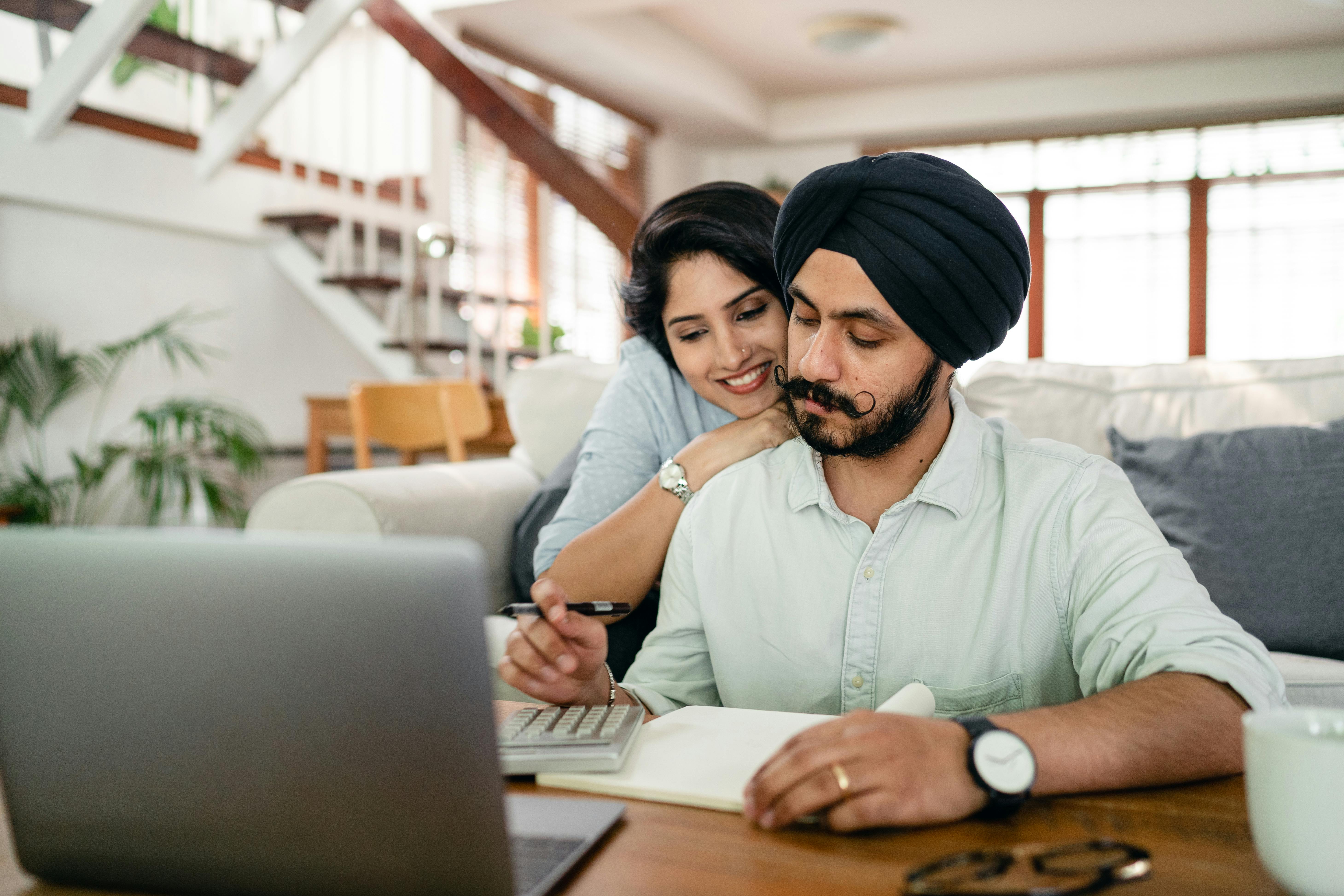 A couple working together at a desk in a cozy living room.