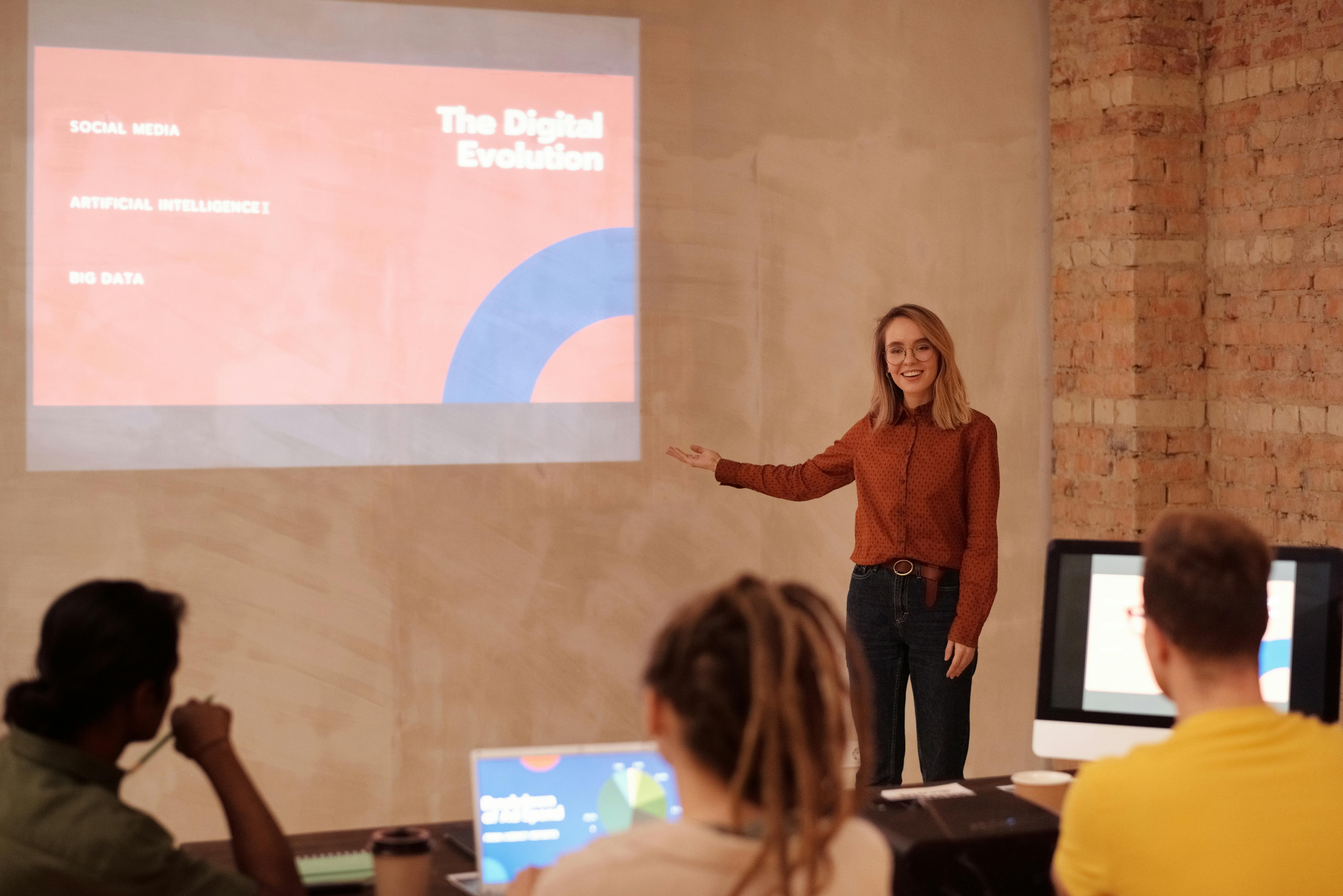 A woman presenting on digital evolution while others listen attentively.