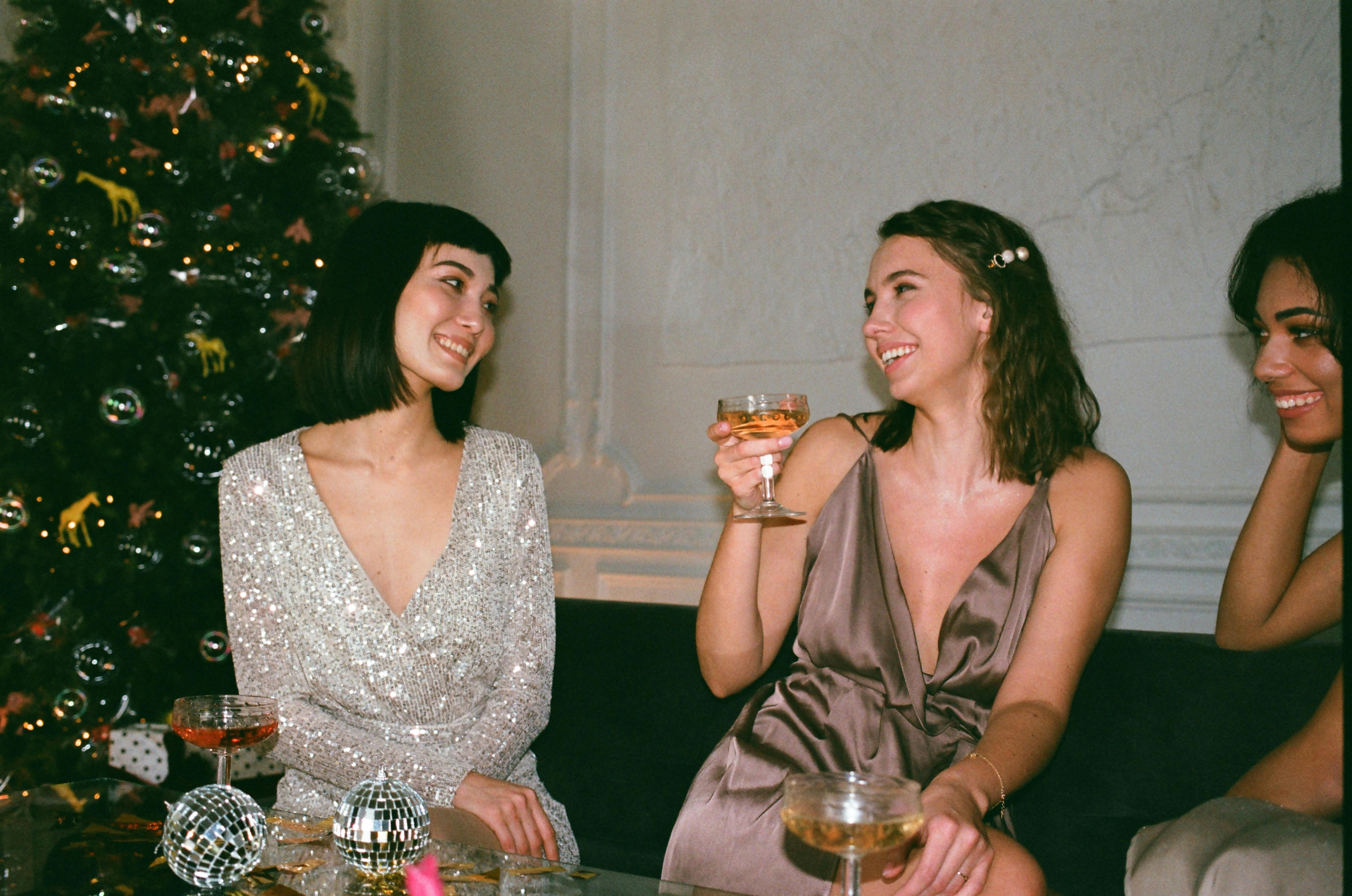 Three friends enjoying drinks together in a festive setting.