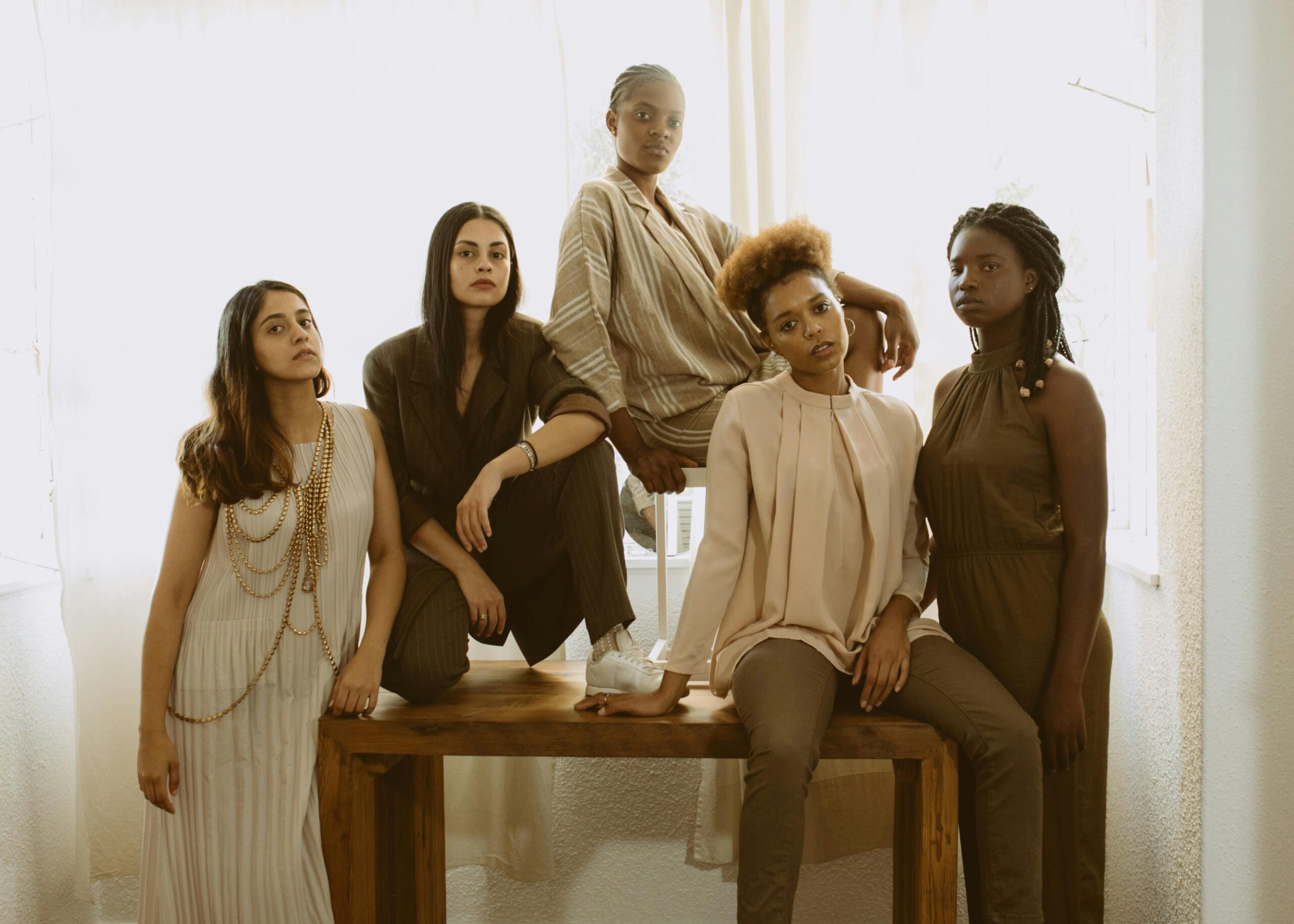 Five women posing together in a fashion photo shoot.