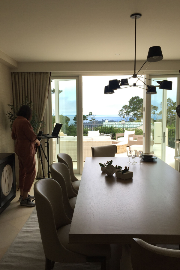 a photographer photographing a dining room and outdoor space