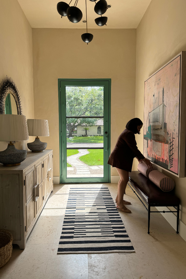 a designer doing a friend a favor by arranging objects in her foyer