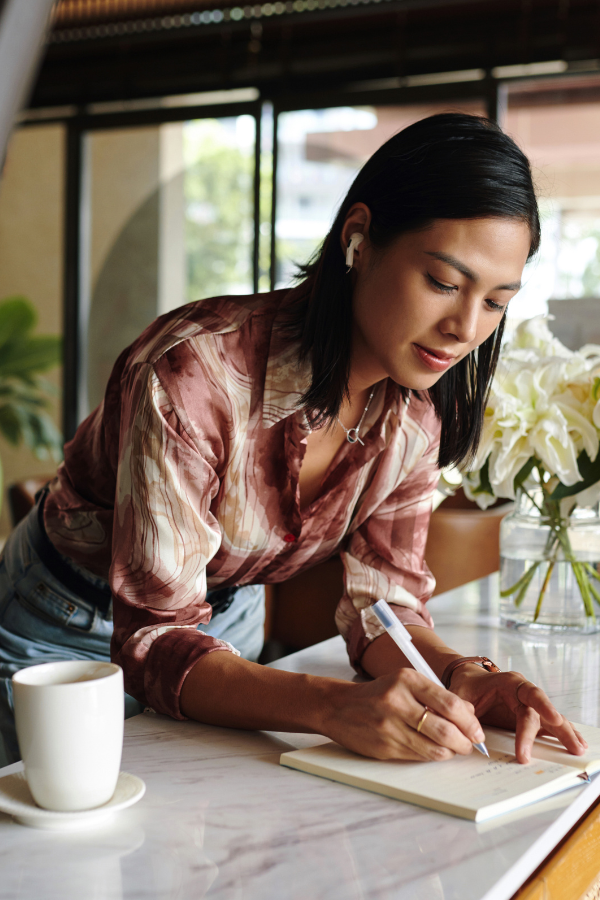 a woman with coffee writing notes