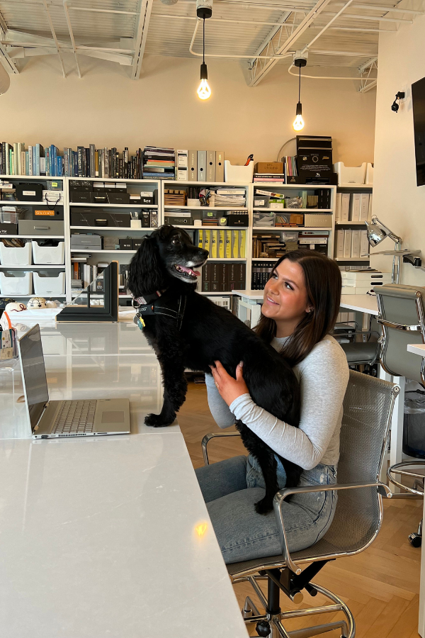 an interior design intern holding a dog in the office
