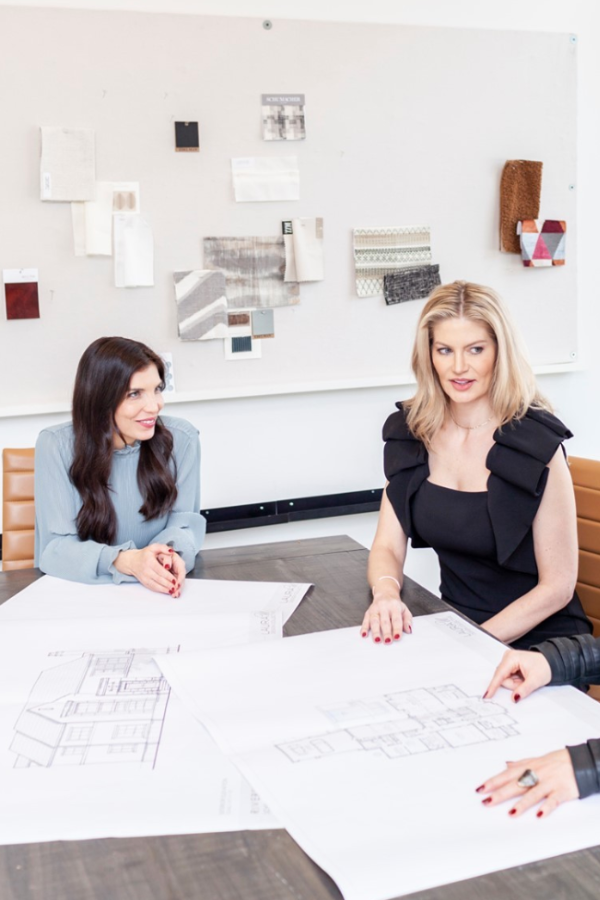 two designers in a studio work with blueprints