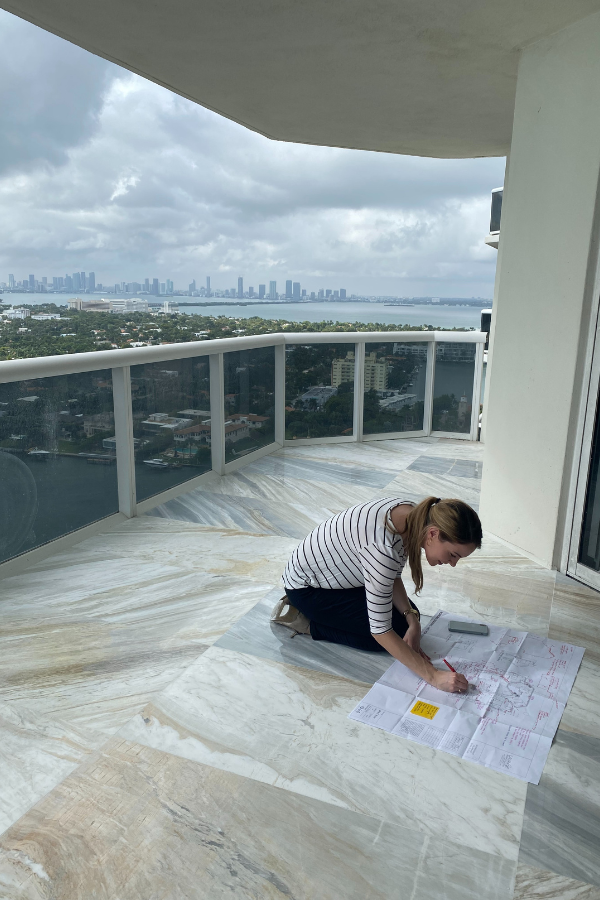 a designer edits plans on site on a balcony