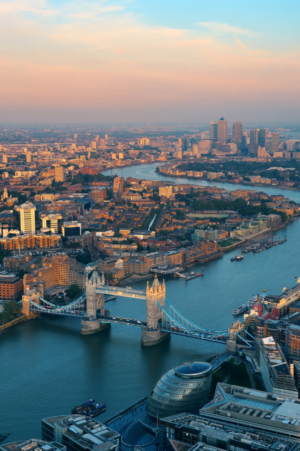 Aerial view of Tower Bridge crossing the River Thames with London's skyline in the background.