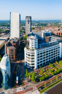 Aerial view of Eindhoven with modern architecture, high-rise buildings, streets, and landscaped public spaces.