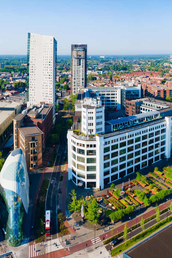 Aerial view of Eindhoven with modern architecture, high-rise buildings, streets, and landscaped public spaces.
