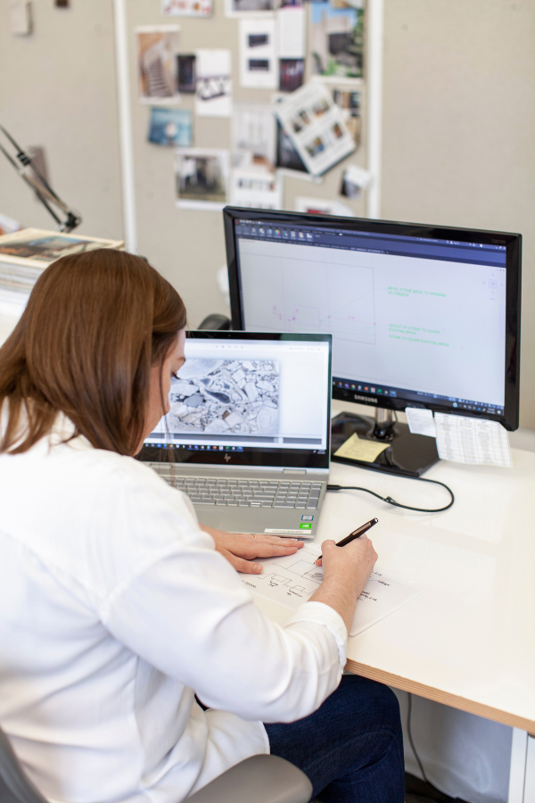 a woman typing at her design in an interior design firm