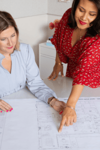 the COO of a design firm looks over plans with an employee