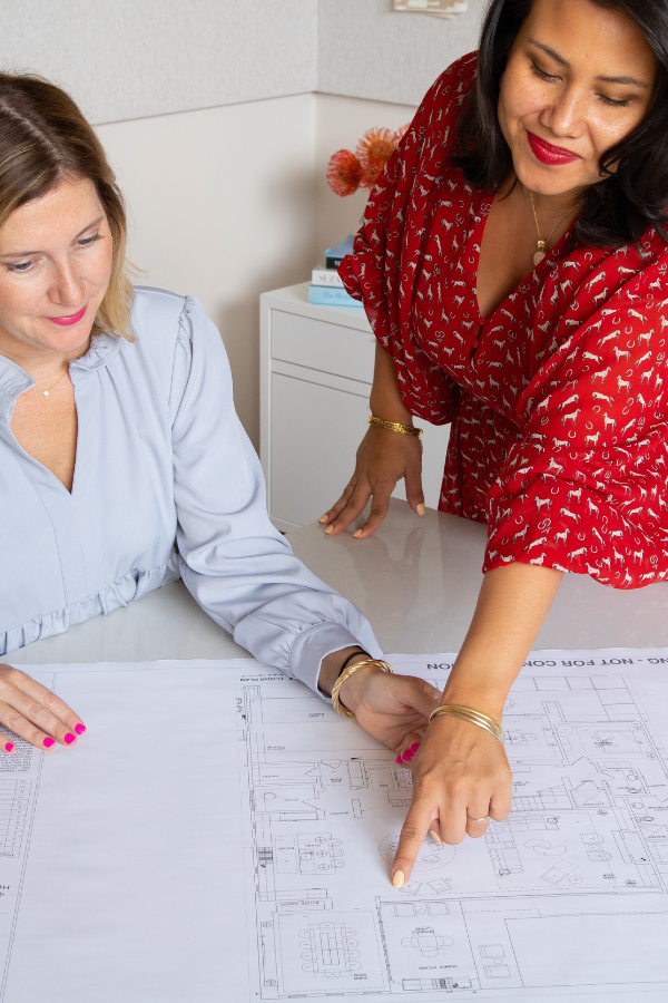 the COO of a design firm looks over plans with an employee